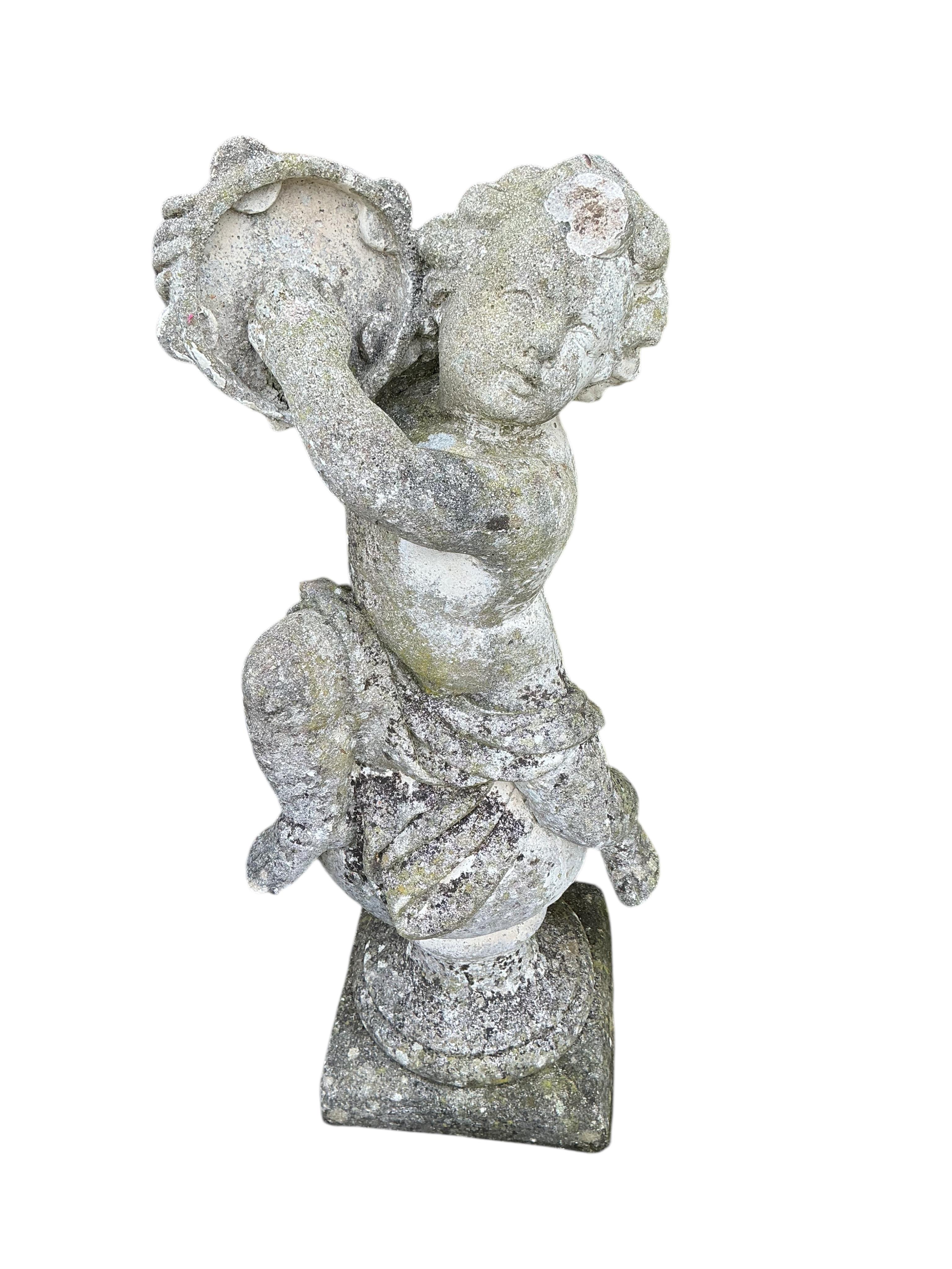 A reconstituted stone garden ornament of a cherub on ball, height 98cm
